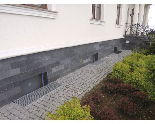 Extérieur d''une maison avec façade en pierre naturelle et chemin pavé