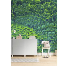 Salon avec papier peint vert à motif de plumes, commode et chaise