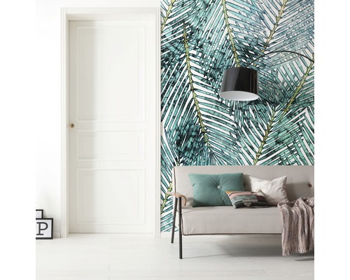 Pièce à vivre avec porte, canapé et papier peint à motif de feuilles de palmier