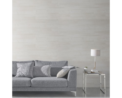 Salon avec canapé gris, coussins, lampe de table et panneaux muraux