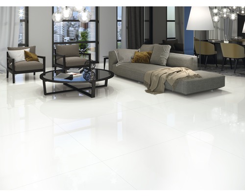 Salon lumineux avec carrelage brillant, canapé, fauteuils et table