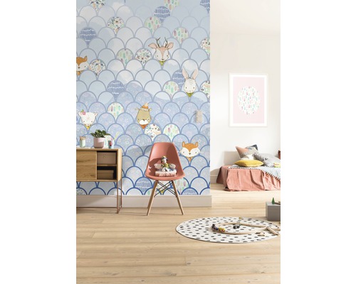 Chambre d''enfant avec papier peint à écailles et motifs d''animaux, décorée avec des meubles et des jouets.