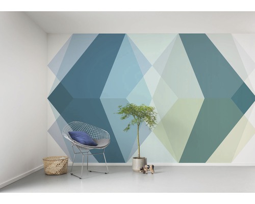 Wohnraum mit geometrischer Tapete, Drahtsessel und Zimmerpflanze