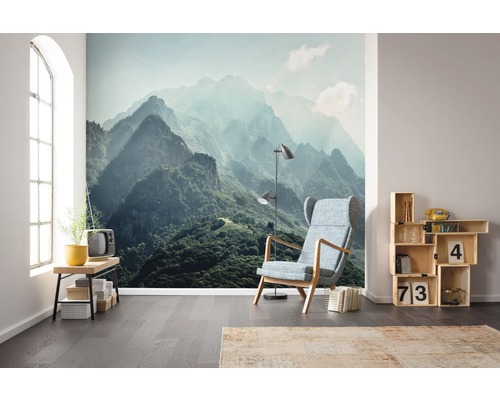 Salon avec papier peint photo paysage de montagne, fauteuil, lampe et étagère en bois