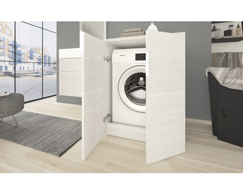 Machine à laver dans un meuble de machine à laver blanc dans la salle de bain
