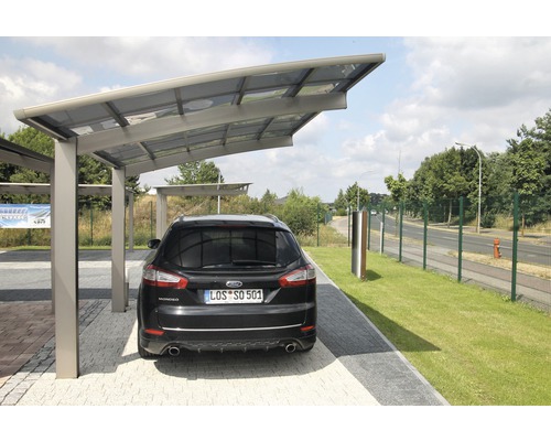 Ein Auto steht unter einem Carport auf einem Parkplatz.