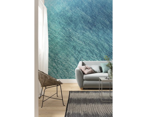 Salon avec papier peint photo à motif marin, canapé, fauteuil et tapis