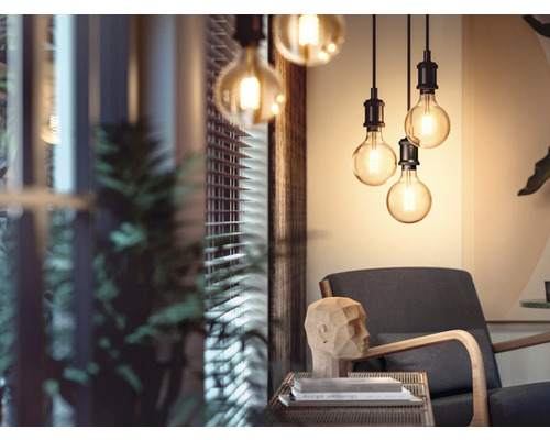 Szene mit Pendelleuchten über einem Sessel in einem Wohnzimmer.