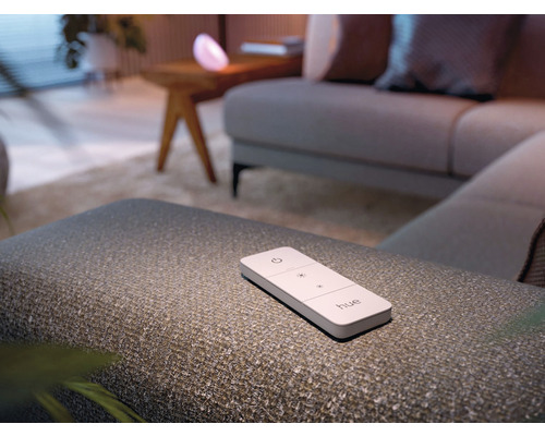 Philips Hue Fernbedienung auf einem Hocker in einem Wohnzimmer