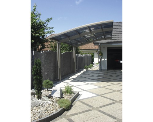 Modernes Carport aus Metall neben einer Garage und einem gepflasterten Weg