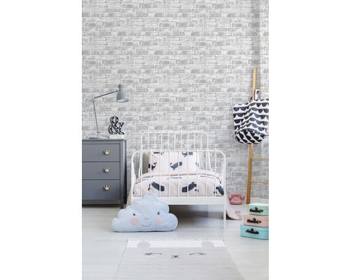 Kinderzimmer mit Bett, Kommode, Leiter und Dekorationsartikeln vor einer Tapete im Backsteindesign