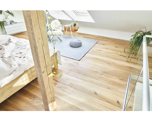 Grenier lumineux avec plancher en bois, lit, tapis et siège