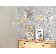 Chambre d''enfant avec papier peint à motifs animaliers, guirlande, images et commode à jouets.