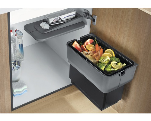 Meuble de cuisine avec poubelle, produits de nettoyage et brosse de nettoyage