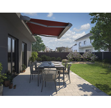 Terrasse mit roter Gelenkarmmarkise, Gartentisch und Stühlen in Wohnhausgarten