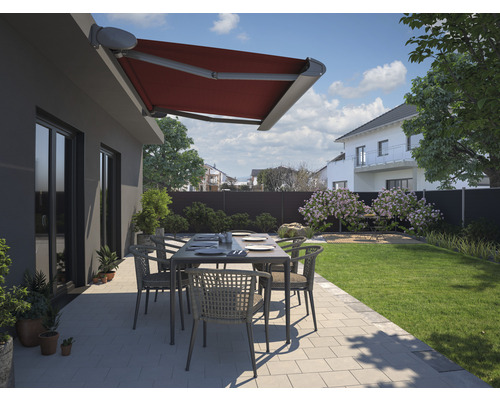 Terrasse mit roter Gelenkarmmarkise, Gartentisch und Stühlen in Wohnhausgarten