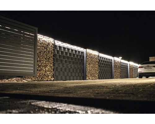 Mur de gabions avec remplissage en bois et clôture attenante de nuit