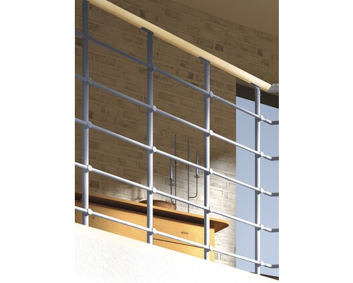 Balustrade en métal avec main courante en bois devant un mur de briques