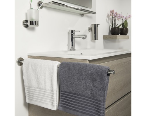 Salle de bains avec lavabo, robinet, serviettes et accessoires de salle de bains
