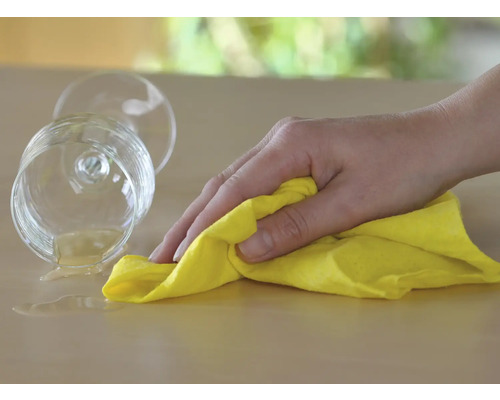 Pouvoir nettoyant : une main essuie une boisson renversée sur une table avec un chiffon de nettoyage.