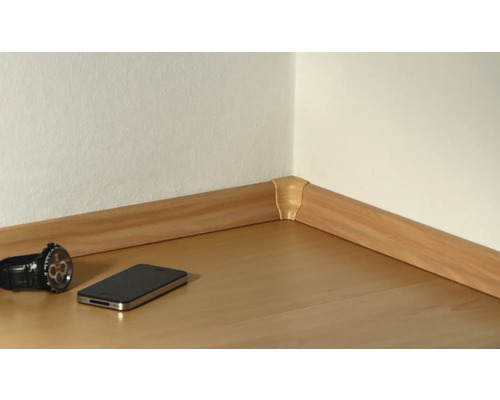 Raumecke mit Holzfussleiste und Eckstück, Smartphone und Armbanduhr