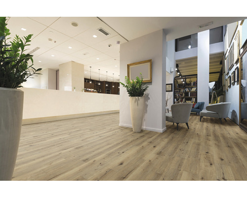 Espace de réception lumineux avec parquet, plantes et sièges.
