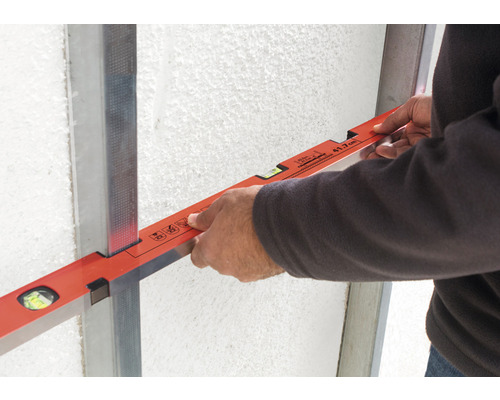 Artisan avec niveau à bulle sur profilé métallique