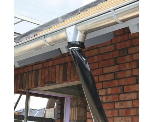 Gouttière en métal avec descente pluviale sur un bâtiment en briques