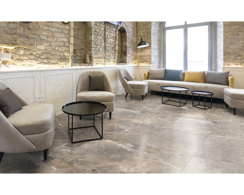 Salon avec carrelage, fauteuils et canapé