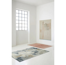Pièce lumineuse avec deux tapis et un tableau au mur.