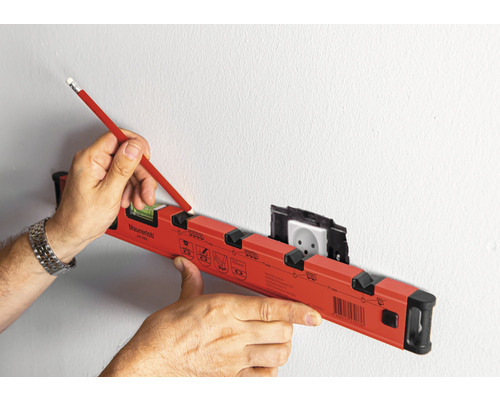 Eine Wasserwaage wird verwendet, um eine Markierung an einer Wand mit einer Steckdose zu erstellen.