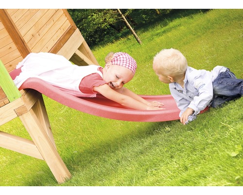 Deux enfants jouent sur un toboggan en bois dans le jardin.