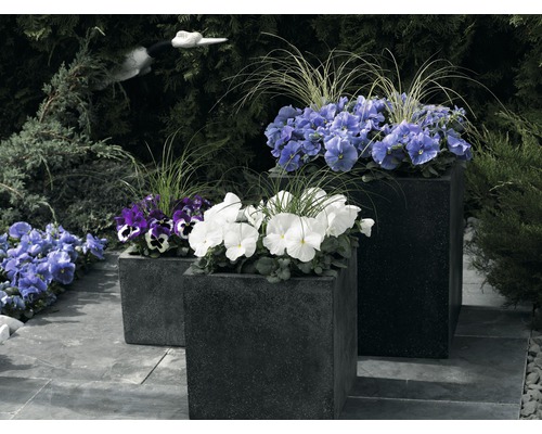 Drei bepflanzte, dunkle Pflanzkästen im Garten.