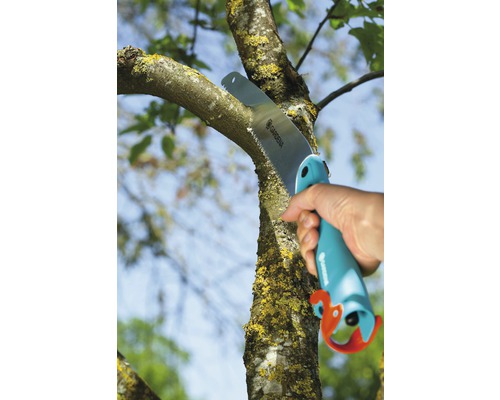 Personne coupant une branche avec une scie à main Gardena