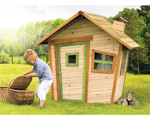 Enfant avec panier de pique-nique devant une cabane de jeu en bois dans le jardin.