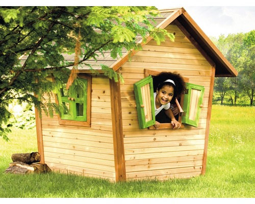 Enfant regardant par la fenêtre d''une cabane en bois dans le jardin.