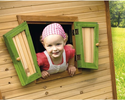 Enfant regardant par la fenêtre d''une cabane de jeu en bois