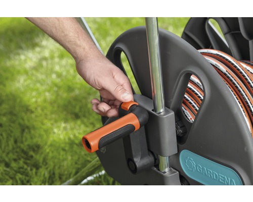 Une personne actionne un dévidoir de tuyau d''arrosage