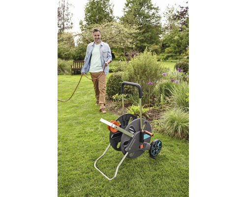 Chariot à tuyau d''arrosage Gardena avec un homme dans le jardin