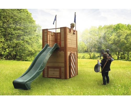 Enfant sur une tour de jeux avec toboggan et drapeaux dans le jardin