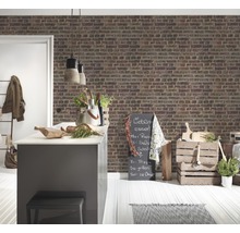 Pièce lumineuse avec îlot de cuisine, mur en briques et éléments décoratifs pour une ambiance chaleureuse.