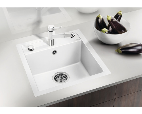 Évier en silgranit avec égouttoir, mitigeur monocommande et quelques aubergines