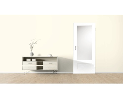 Pièce lumineuse avec commode, décoration et porte intérieure avec insert en verre.