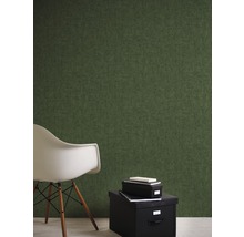 Pièce avec papier peint intissé vert, boîte de rangement noire et chaise blanche