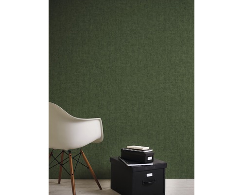 Pièce avec papier peint intissé vert, boîte de rangement noire et chaise blanche