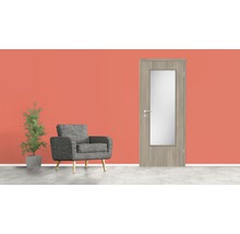 Porte intérieure en bois avec insert en verre, fauteuil et plante en pot devant un mur