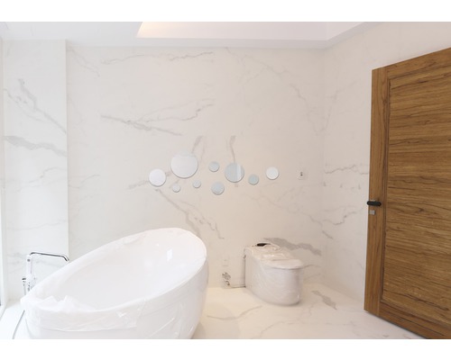 Salle de bain moderne avec baignoire îlot, toilettes et miroirs ronds en décoration