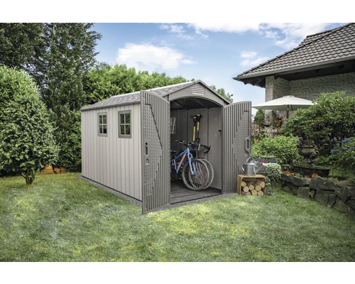 Scène de jardin avec remise à outils, ouverte avec des vélos, des outils, des ustensiles de jardin et du bois