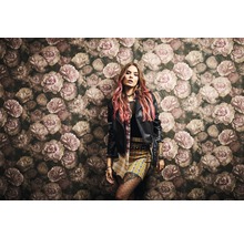 Frau vor einer Wand mit floralem Muster