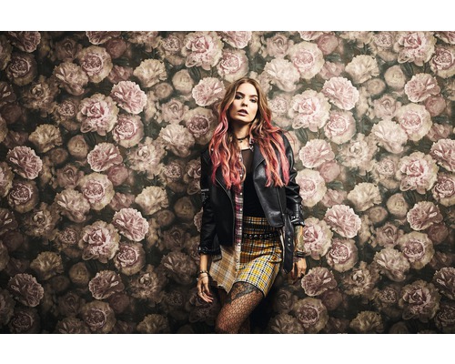 Frau vor einer Wand mit floralem Muster